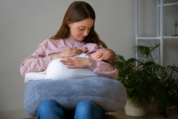 Medium shot mother with cute newborn