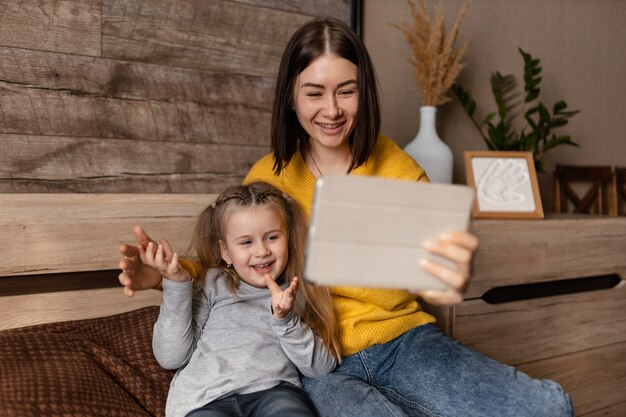 Medium shot mother with kid and laptop