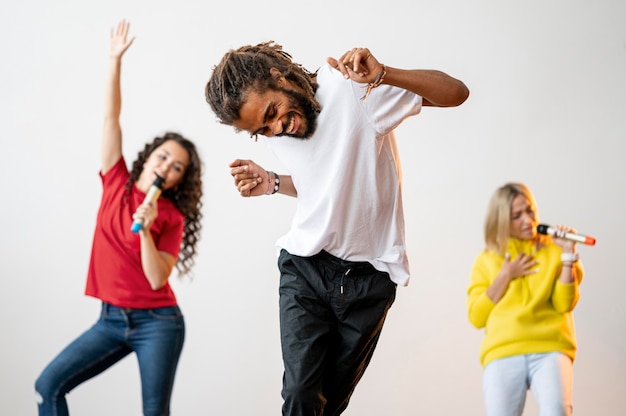 Medium shot multiracial people singing and dancing