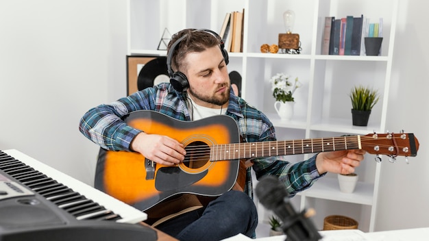 Foto gratuita musicista di tiro medio che suona la chitarra