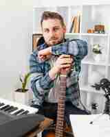 Free photo medium shot musician posing with guitar