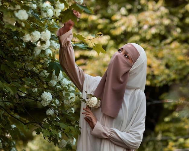 야외에서 포즈를 취하는 중간 샷 이슬람 여성
