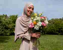 Free photo medium shot muslim woman posing with flowers