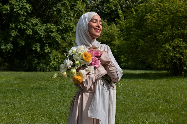 Medium shot muslim woman posing with flowers