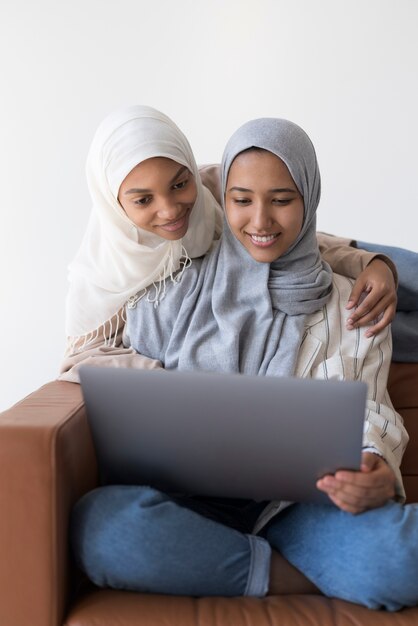 ノートパソコンでミディアムショットのイスラム教徒の女性
