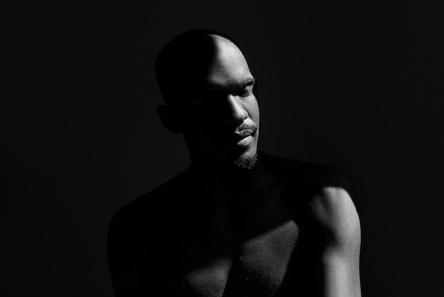 Medium shot naked man posing with dark background