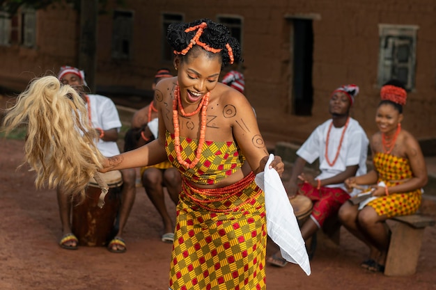 Средний снимок нигерийской женщины, танцующей на открытом воздухе