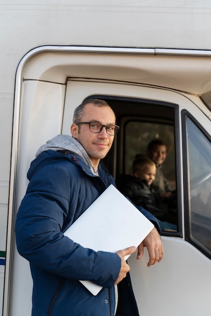 Free photo medium shot nomad family with campervan