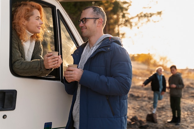 Free photo medium shot nomad family with campervan