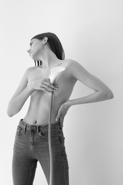 Medium shot nude woman posing with flower