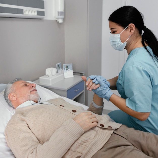 medium shot nurse holding patient's hand