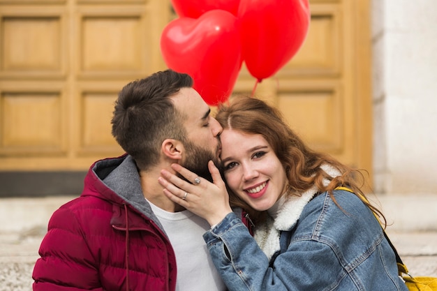 無料写真 ガールフレンドにキスをする男性のミディアムショット