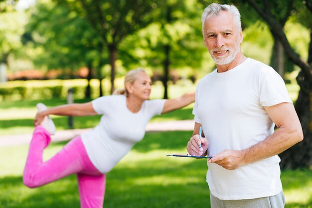 Medium shot old couple exercising outdoors