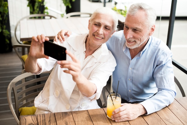 Medium shot old couple taking a selfie