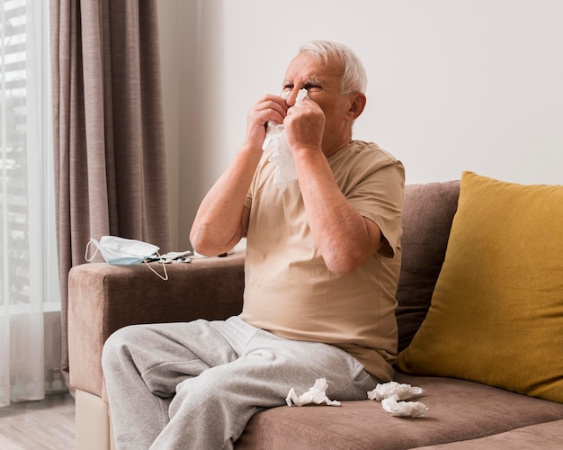 Free photo medium shot old man blowing his nose