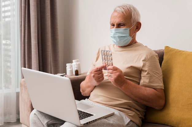 Medium shot old man holding pills blisters