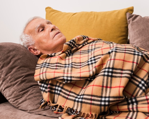 Free photo medium shot old man laying on couch