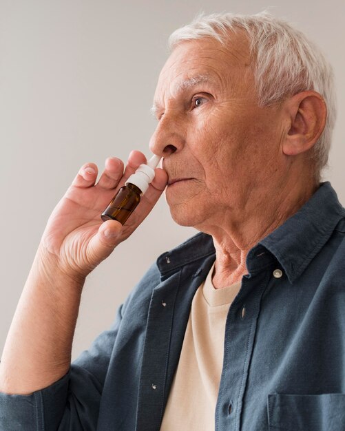 Medium shot old man using nasal spray