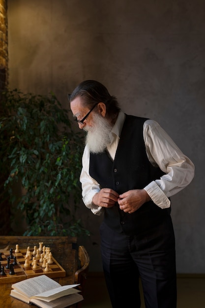 Free photo medium shot old man with book indoors