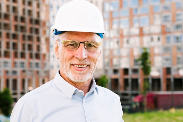 Free photo medium shot old man with glasses and safety helmet