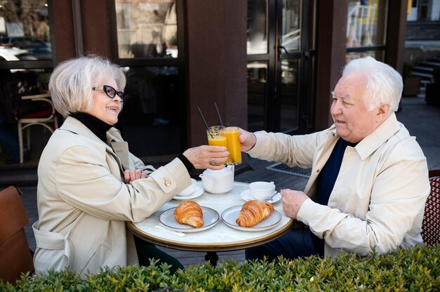 Medium shot old people clinking glasses