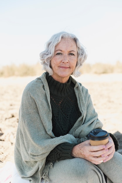 Medium shot old woman on the beach