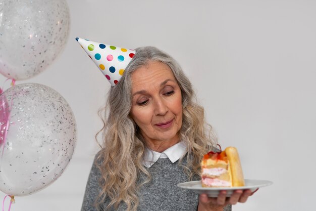 Medium shot old woman holding cake