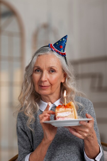 Medium shot old woman holding cake