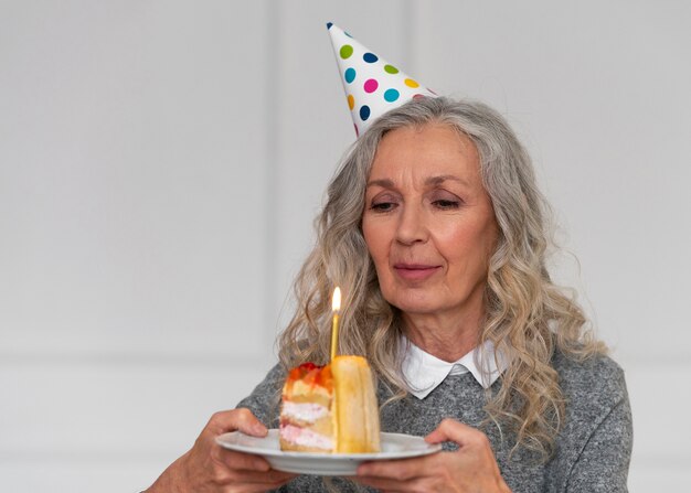 Medium shot old woman holding cake