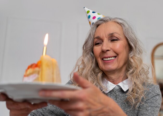 Medium shot old woman holding cake