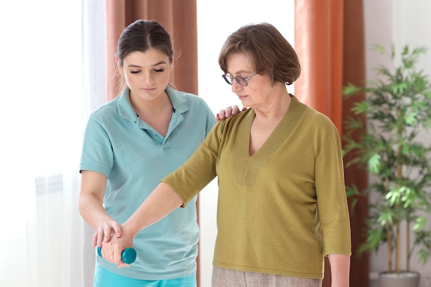 Medium shot old woman holding dumbbell