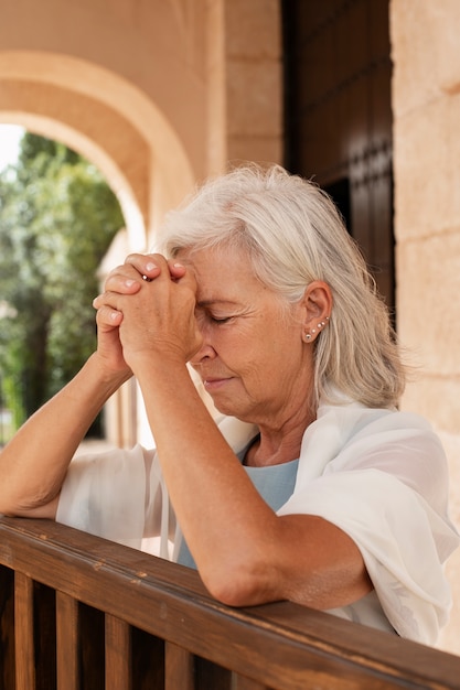 Foto gratuita mediamente sparato vecchia donna che prega