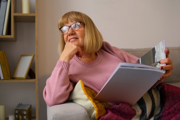 Free photo medium shot old woman reading at home