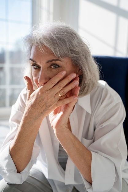 Free photo medium shot old woman sitting on chair