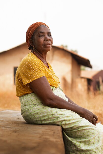 Medium shot old woman sitting outdoors