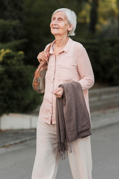 Free photo medium shot old woman walking in park