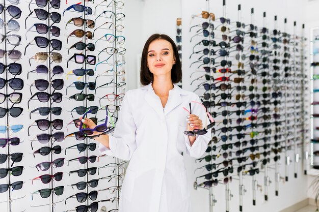 Medium shot of optician holding sunglasses pairs