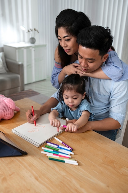 Medium shot parents and kid at desk