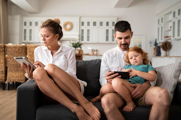 Medium shot parents and kid with devices