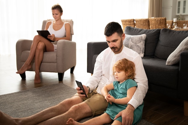 Medium shot parents and kid with devices