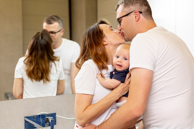 Medium shot parents kissing in the bathroom