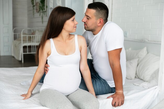 Medium shot parents looking at each other in bed