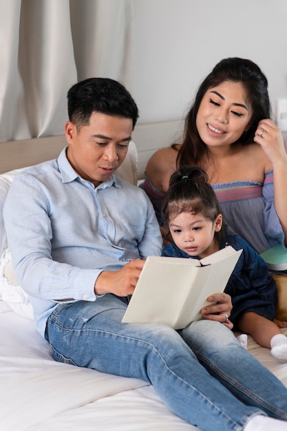 Родители среднего кадра читают ребенку