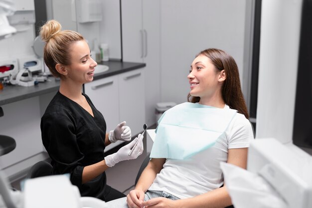 Medium shot patient and dentist at clinic