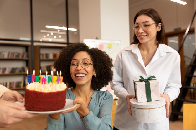 Medium shot people celebrating with cake