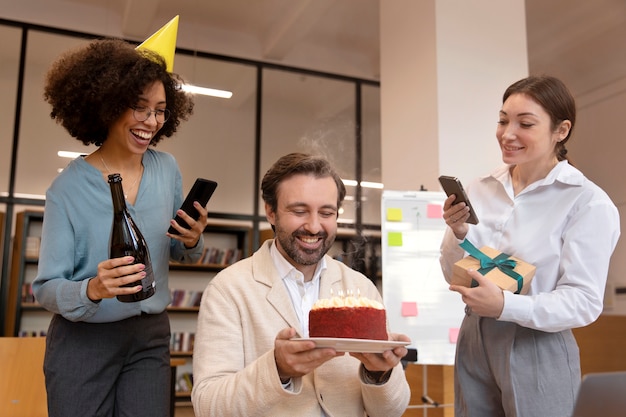 Medium shot people celebrating with cake