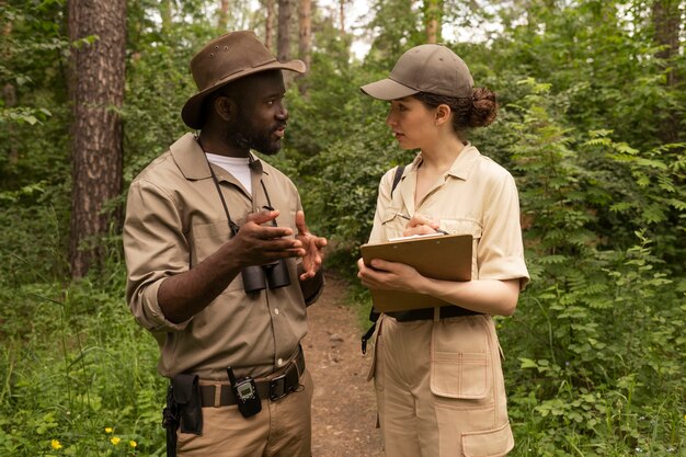 Medium shot people chatting in forest