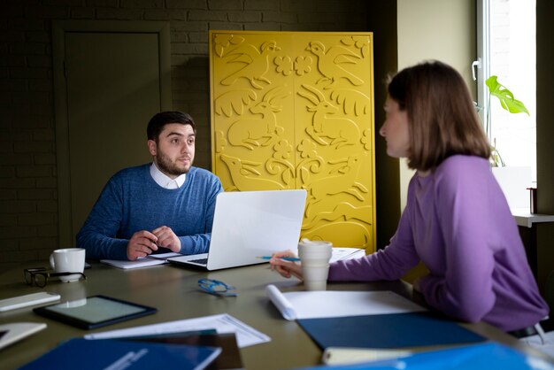 Medium shot people chatting at work