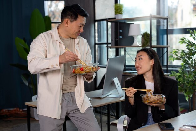아시아 음식을 먹는 중간 샷 사람들