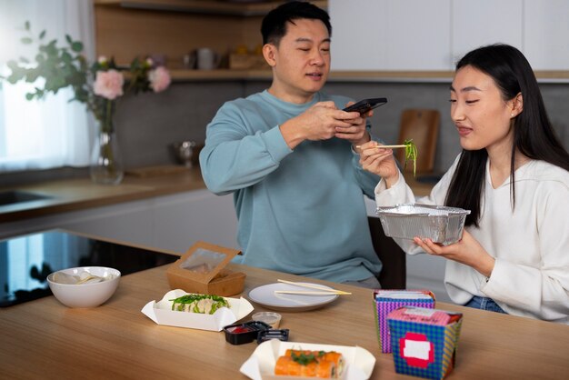 아시아 음식을 먹는 중간 샷 사람들